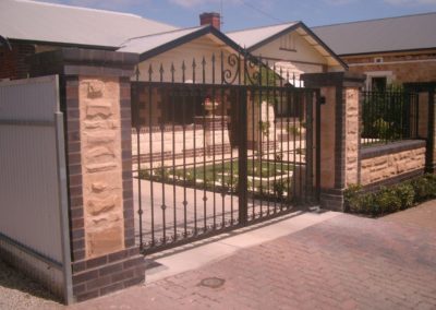 contemporary-design-double-driveway-steel-gates-mounted-between-two-pillars-and-a-complimentary-stone-and-brick-tudor-style-fence