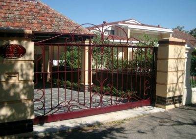 ornate-victorian-design-burgundy-painted-double-driveway-gates-in-heritage-listed-fence